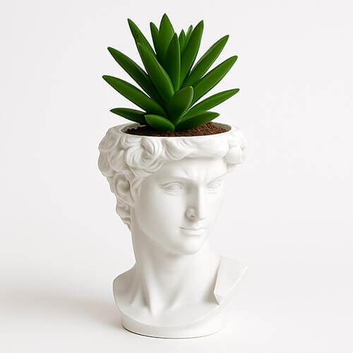White 3D printed David bust planter with green succulent on a white background.