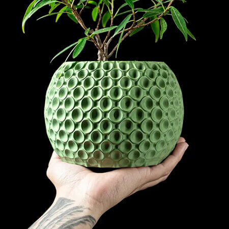 Green textured 3D printed PLA planter with circular bubble pattern, holding small bonsai plant, modern handcrafted design by Plantale.