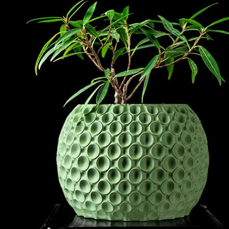 Green textured 3D printed PLA planter with circular bubble design and small bonsai plant, modern handcrafted look by Plantale.