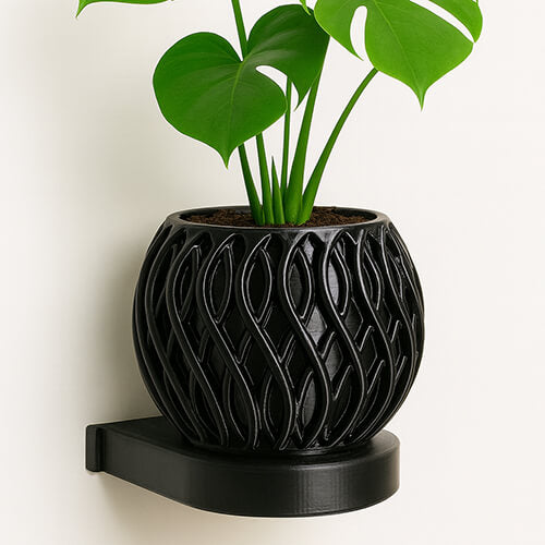 Black wave-textured 3D printed PLA wall-mounted planter with green Monstera plant.