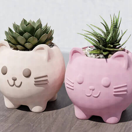 Pink and beige cat-shaped 3D printed PLA planters with succulents, cute minimalist pet-inspired design on wooden surface, by Plantale.