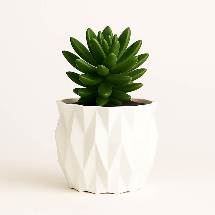 White faceted 3D printed PLA planter with geometric diamond texture, holding green succulent plant, modern minimalist tabletop decor by Plantale.