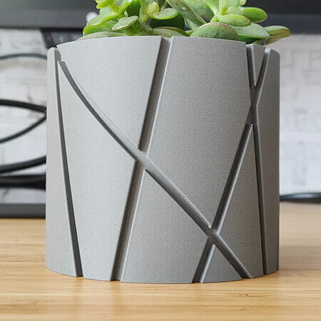 Gray linework 3D printed PLA planter with diagonal carved pattern, holding small succulent plant, modern minimalist tabletop decor by Plantale.
