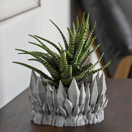 Black crystal mountain 3D printed PLA planter with green succulent plant, geometric crystal design, displayed on wooden table, by Plantale.