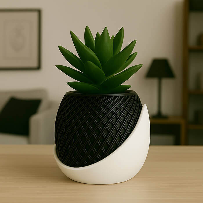 Modern black and white dual-tone 3D printed PLA planter with geometric wrap design and succulent plant on wooden table.