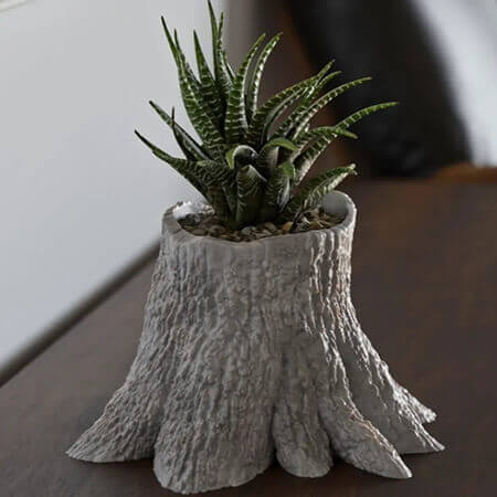 Brown tree trunk 3D printed PLA planter with green succulent plant, realistic bark texture and natural stump design, by Plantale.