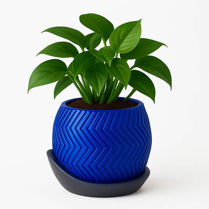 Blue chevron 3D printed PLA planter with zigzag textured pattern and dark gray tray, holding green indoor plant, modern decorative design by Plantale.