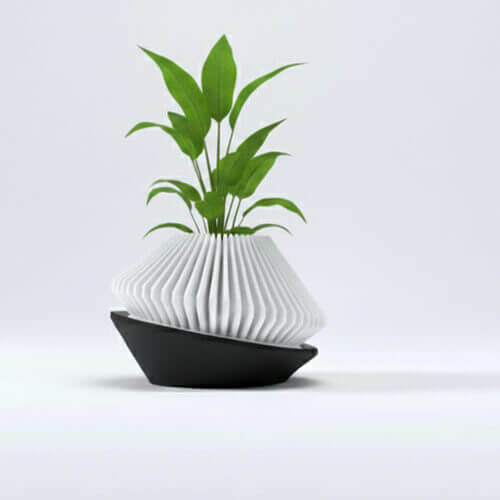 Dual-tone geometric 3D printed modern planter with green plant.